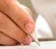 small image of person writing with pen